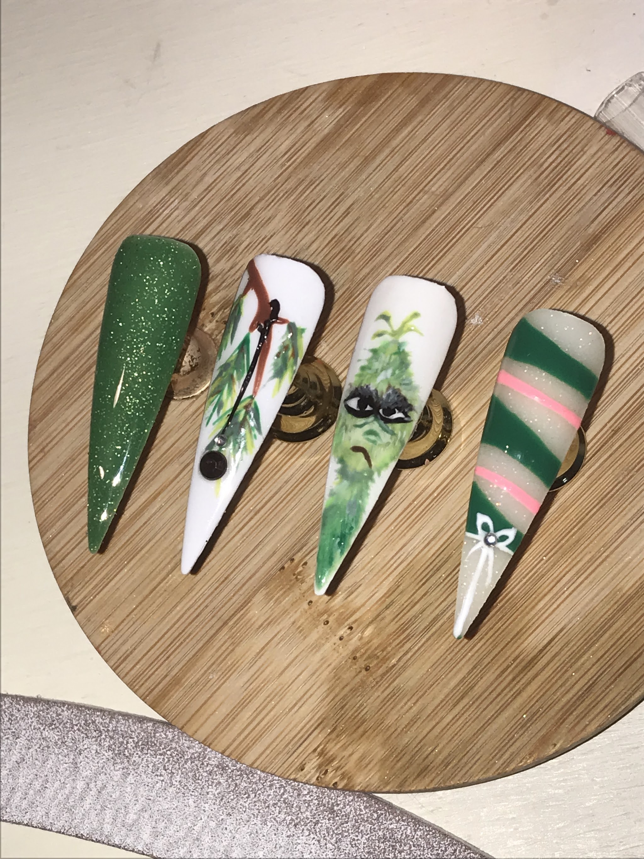Groene nagelontwerpen met handgeschilderde figuren en strepen