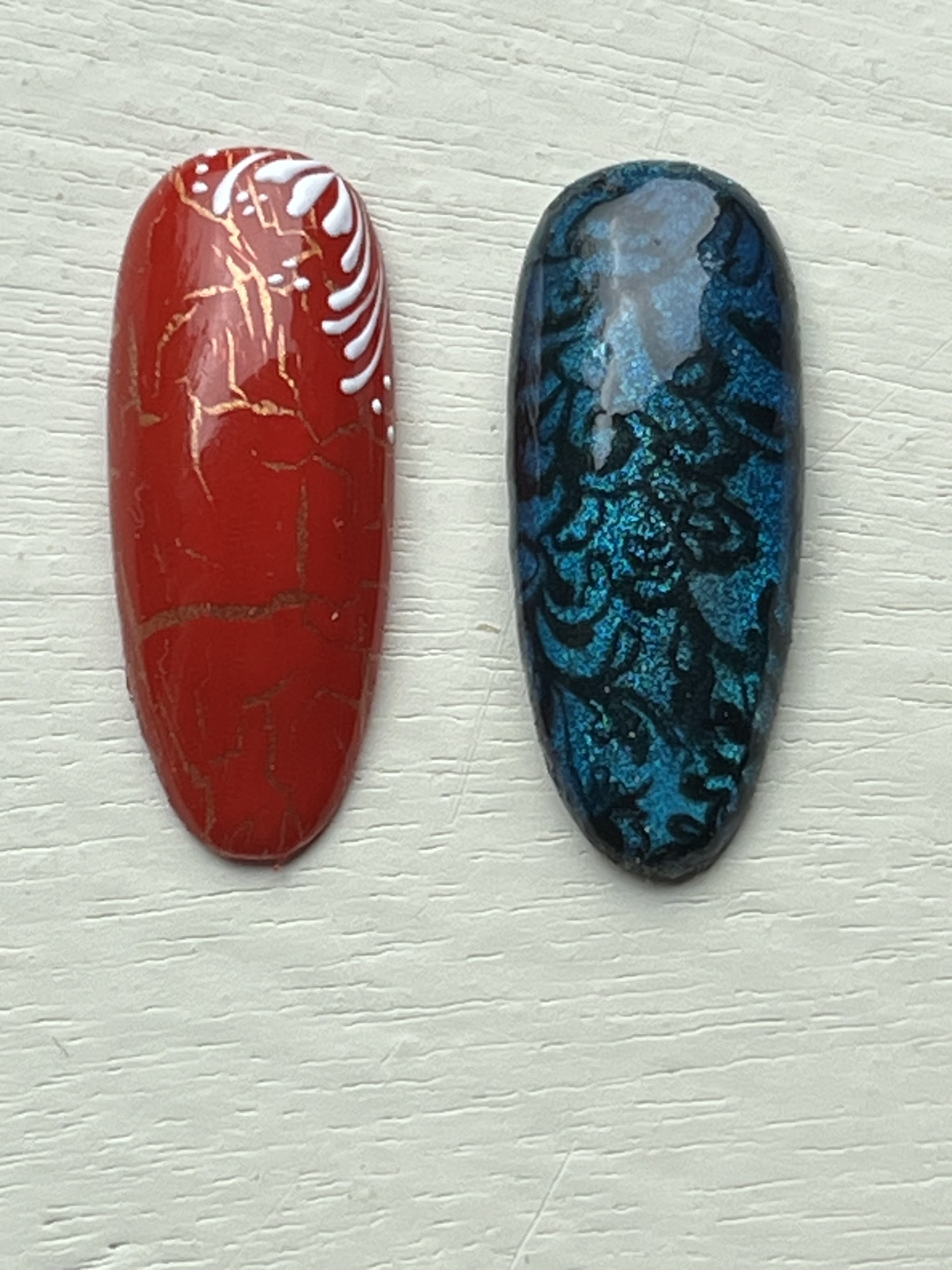 Rood en blauw nagelvoorbeeld met fijne geschilderde patronen