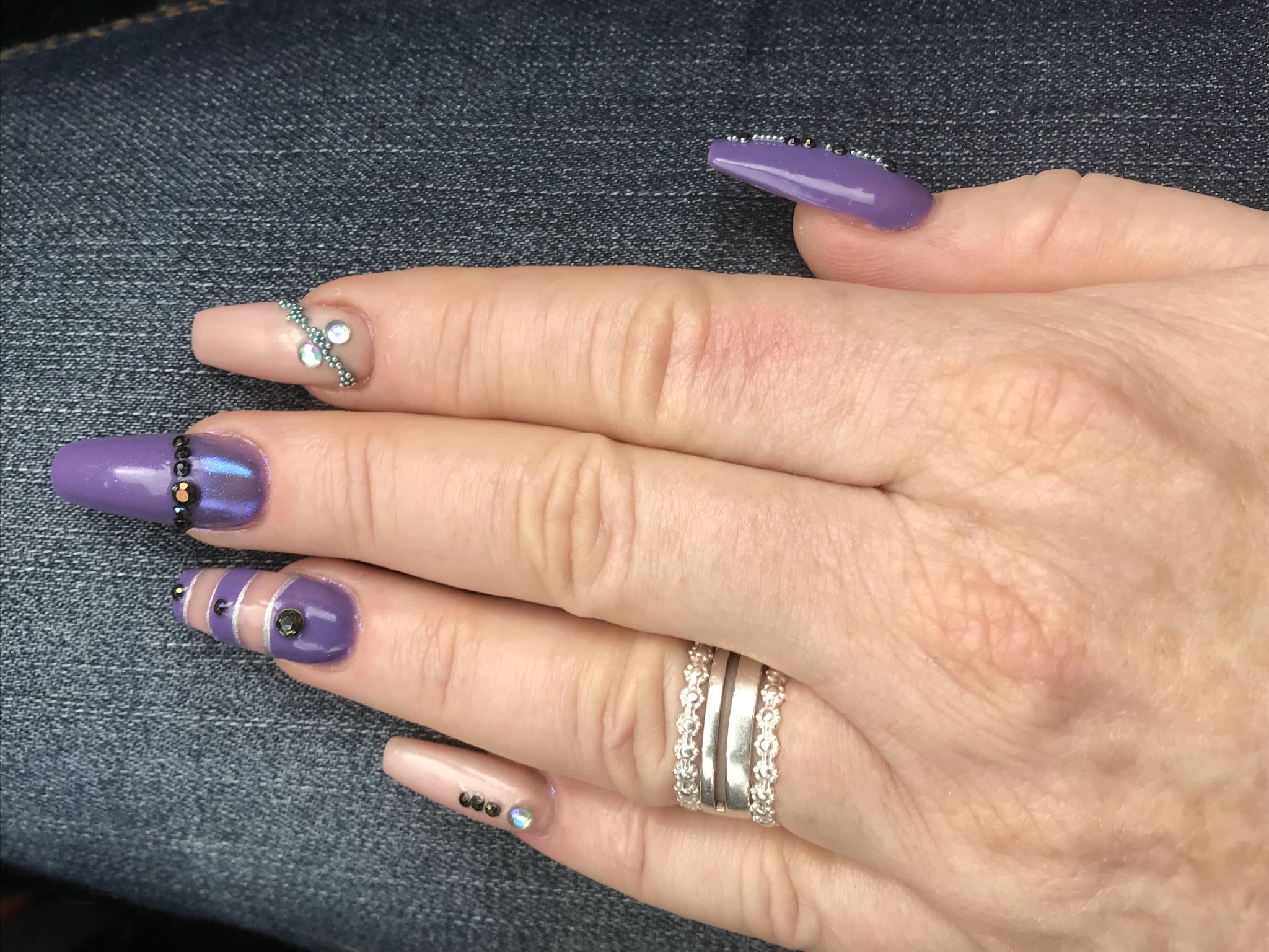 Paarse nagels met glanzende accenten op een hand